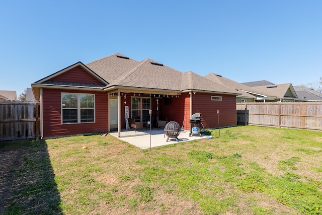 rear view of property featuring a yard, roof with shingles, a fenced backyard, and a patio area