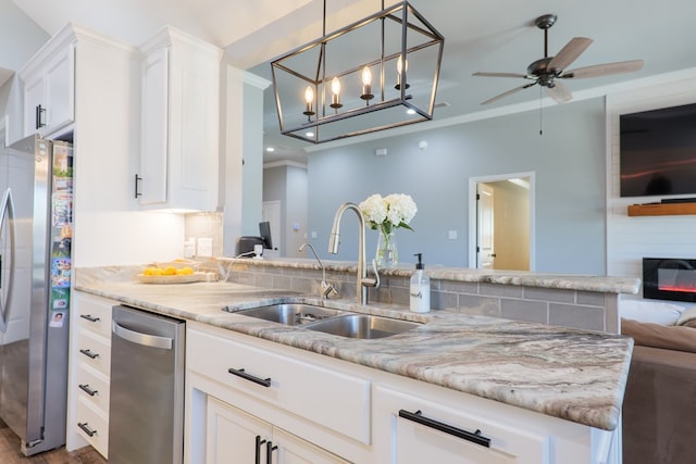 kitchen featuring ornamental molding, a sink, open floor plan, white cabinetry, and freestanding refrigerator