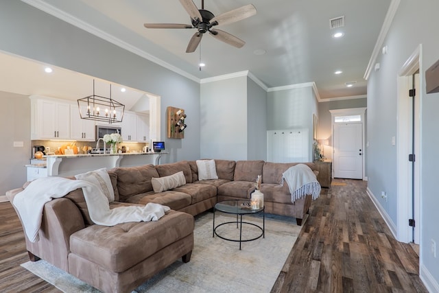 living room with wood finished floors, visible vents, baseboards, recessed lighting, and ornamental molding