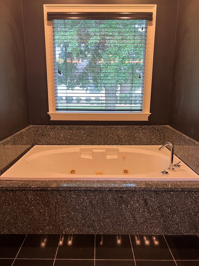 bathroom with tile patterned floors and tiled bath