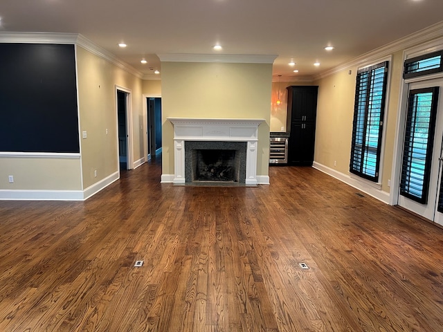 unfurnished living room with dark hardwood / wood-style floors, beverage cooler, and ornamental molding