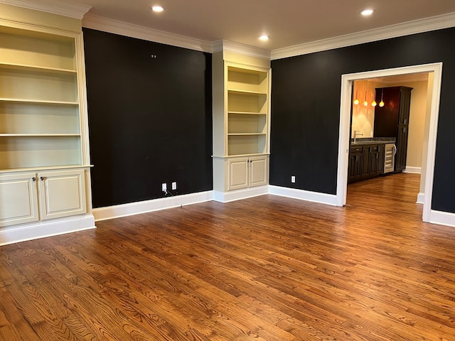 unfurnished living room featuring hardwood / wood-style flooring and ornamental molding