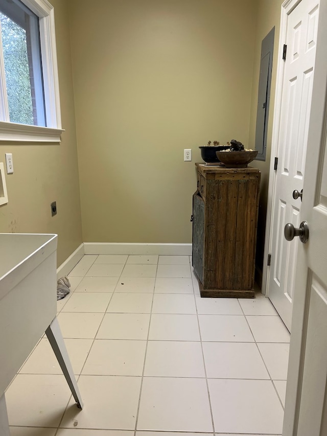 laundry room featuring electric dryer hookup and light tile patterned flooring