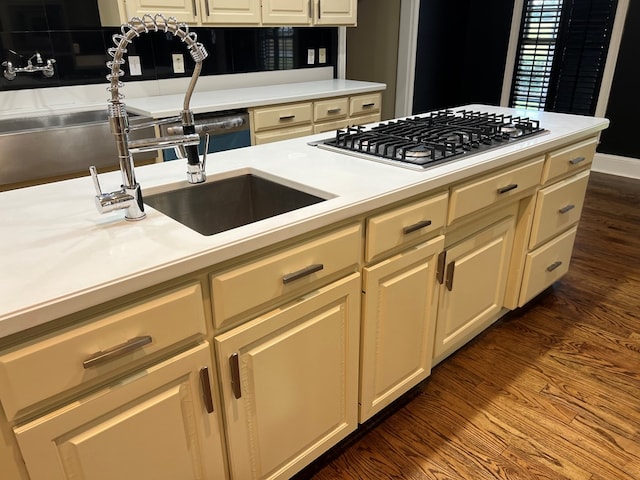 kitchen with cream cabinets, sink, dark wood-type flooring, and stainless steel gas cooktop