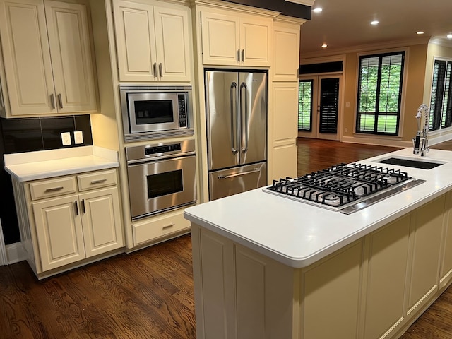 kitchen with sink, ornamental molding, dark hardwood / wood-style flooring, white cabinetry, and stainless steel appliances