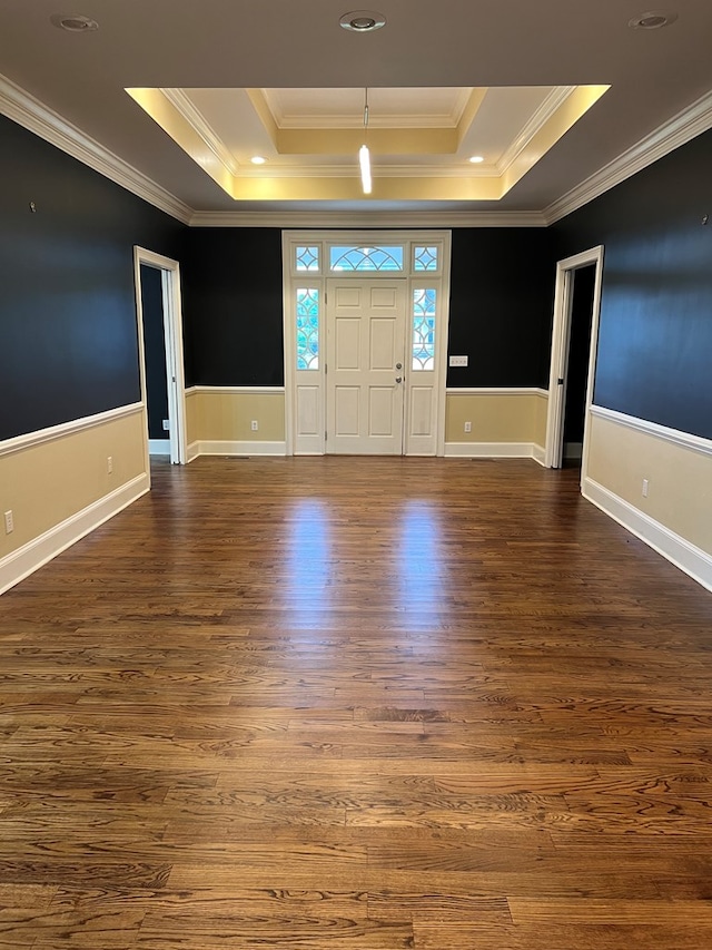 entrance foyer with dark hardwood / wood-style floors, a raised ceiling, and crown molding