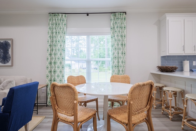 dining area featuring ornamental molding and light hardwood / wood-style floors