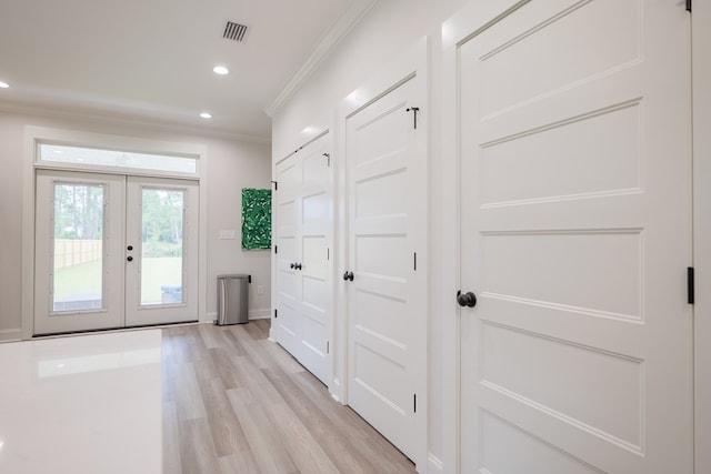 doorway with crown molding, light hardwood / wood-style floors, and french doors