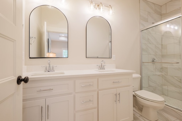 bathroom with toilet, vanity, and a shower with shower door