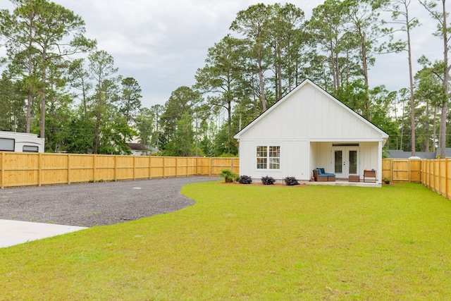 back of property featuring a yard and french doors