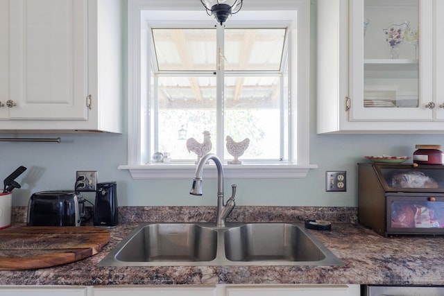 kitchen featuring white cabinetry and sink