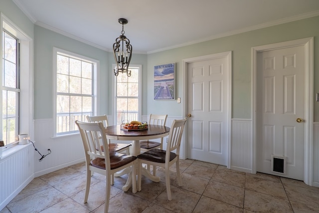 dining space with ornamental molding, light tile patterned floors, and a chandelier