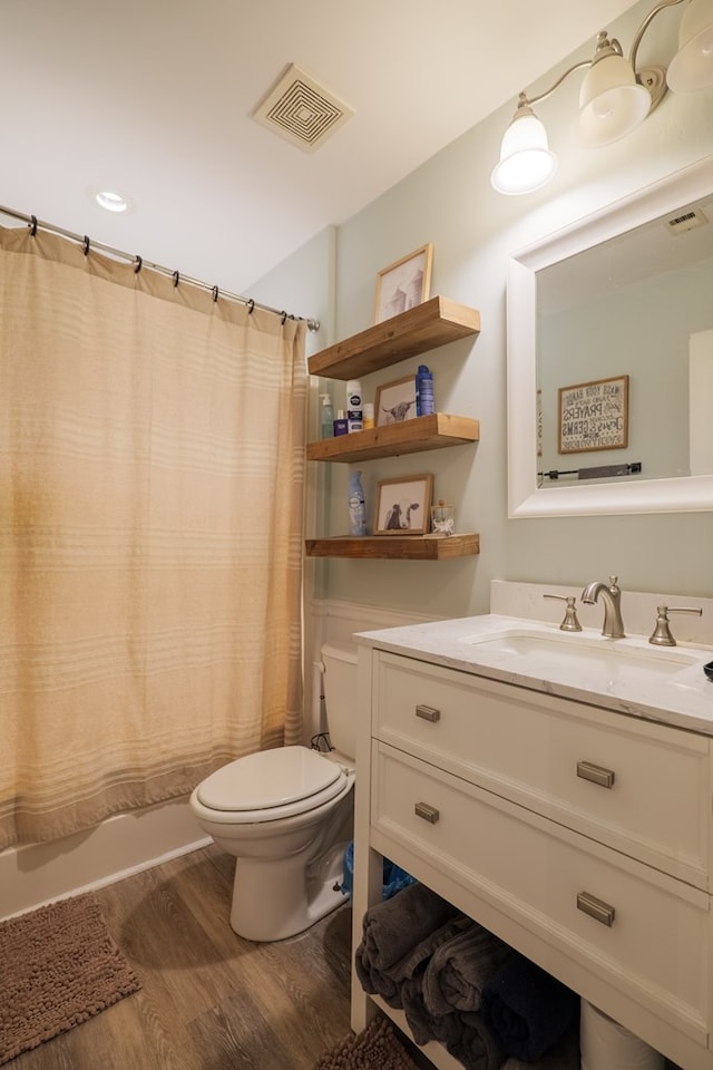 full bathroom with shower / bath combo with shower curtain, wood-type flooring, toilet, and vanity