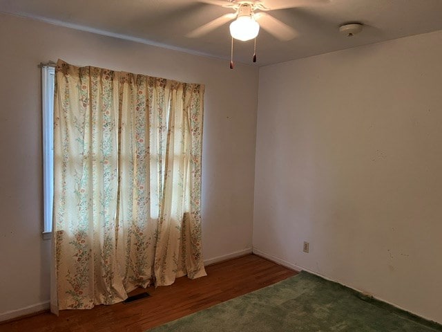 empty room with hardwood / wood-style flooring and ceiling fan