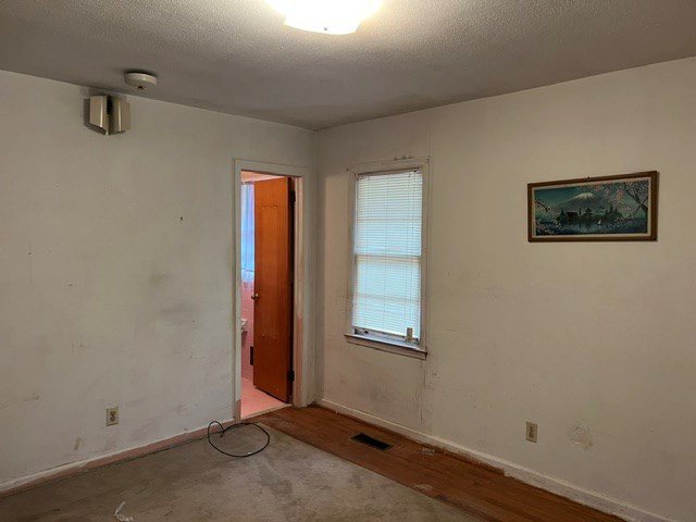 unfurnished room featuring a textured ceiling