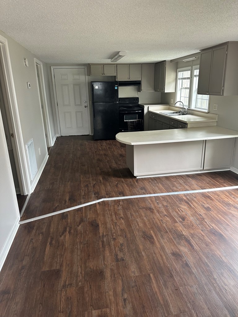 kitchen with gray cabinets, black appliances, and a textured ceiling