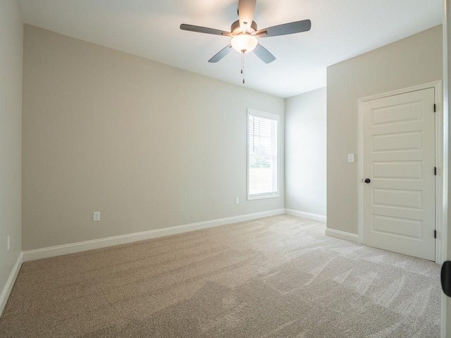 unfurnished room featuring ceiling fan and light carpet