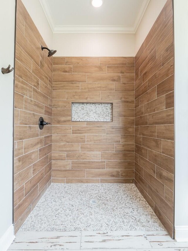 bathroom featuring tiled shower and ornamental molding