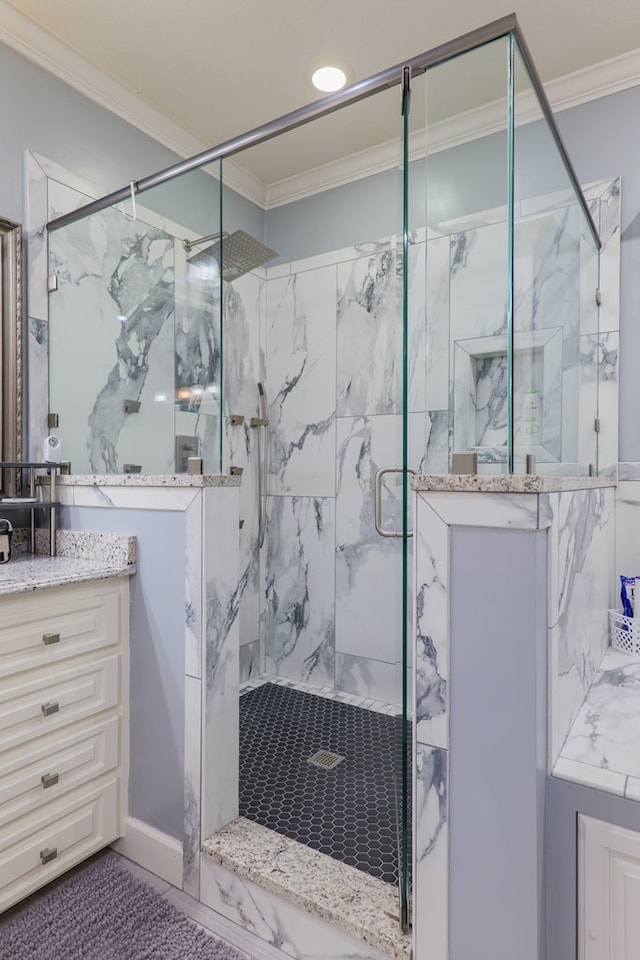 bathroom featuring vanity, a shower with shower door, and ornamental molding