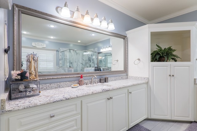 bathroom featuring vanity, a shower with shower door, and ornamental molding