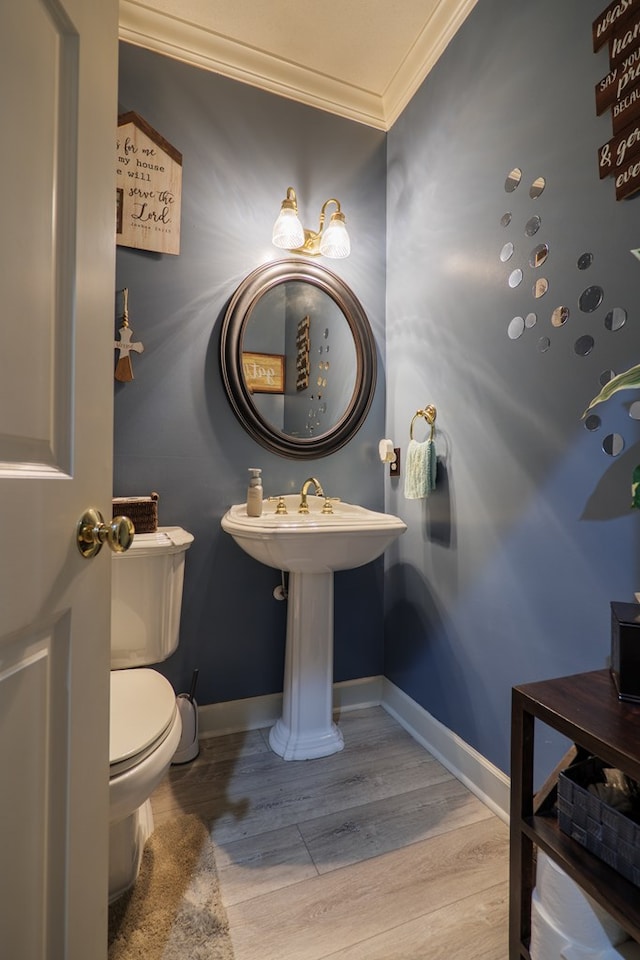 bathroom featuring hardwood / wood-style flooring, toilet, and ornamental molding