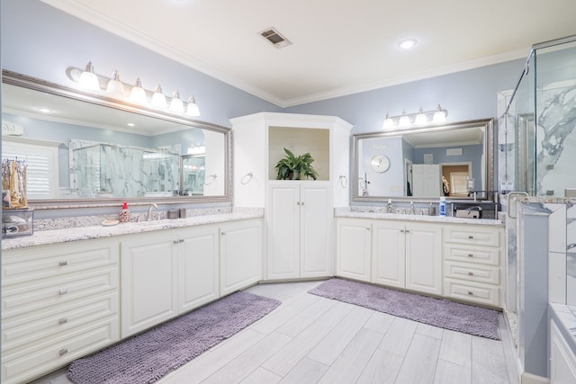 bathroom with vanity, a shower with door, and ornamental molding