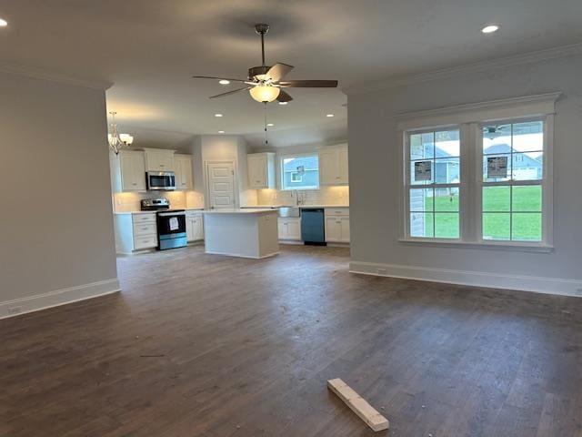 unfurnished living room with ornamental molding, ceiling fan with notable chandelier, and dark wood-type flooring