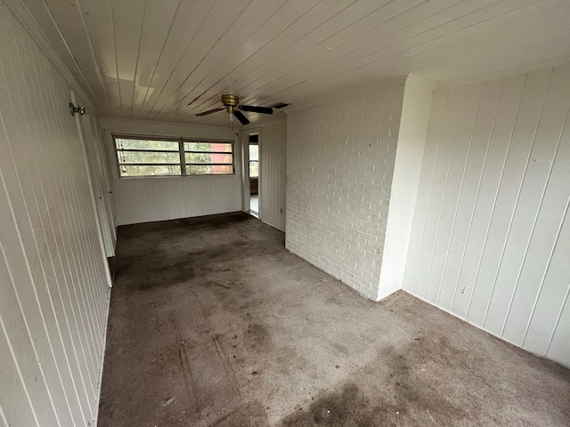 interior space featuring wood ceiling, visible vents, ceiling fan, and brick wall