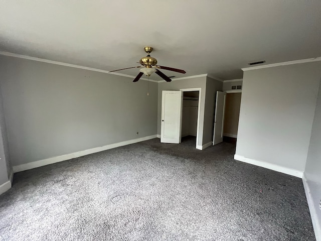 unfurnished bedroom with visible vents, baseboards, a closet, dark carpet, and crown molding