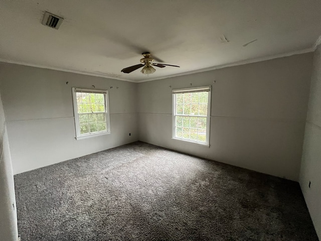 unfurnished room featuring a healthy amount of sunlight, carpet floors, visible vents, and ornamental molding