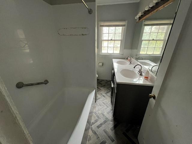 full bathroom with double vanity, a tub to relax in, toilet, and a sink