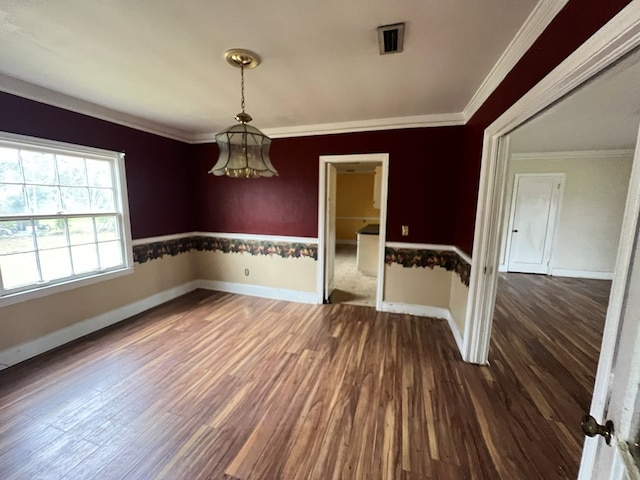 unfurnished dining area featuring baseboards, visible vents, ornamental molding, and dark wood-style flooring