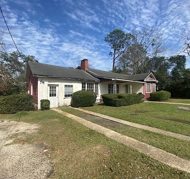 single story home with a front lawn and a chimney