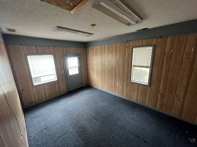 spare room with a textured ceiling, visible vents, and a wealth of natural light