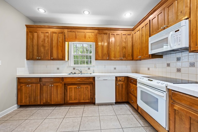4143 Whithorn Way, Valdosta, GA 31605 - kitchen featuring white appliances, a sink, tile countertops, brown cabinetry, and decorative backsplash