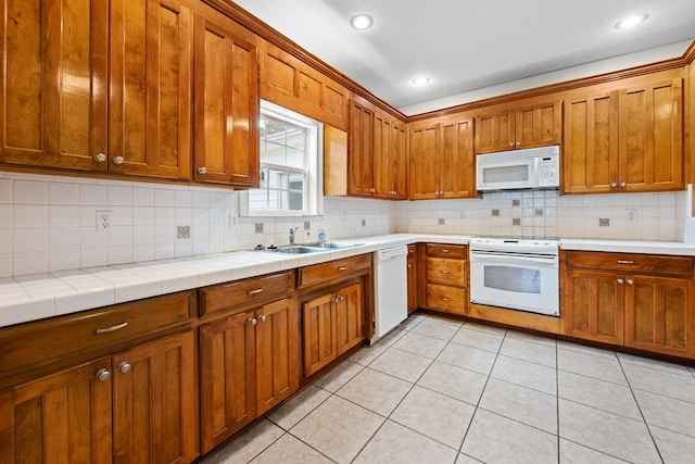 4143 Whithorn Way, Valdosta, GA 31605 - kitchen with white appliances, a sink, brown cabinetry, backsplash, and recessed lighting