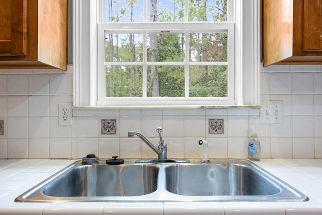 4143 Whithorn Way, Valdosta, GA 31605 - kitchen featuring a sink, tile counters, brown cabinets, and tasteful backsplash