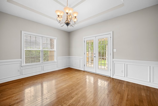 4143 Whithorn Way, Valdosta, GA 31605 - spare room featuring a chandelier, a wainscoted wall, hardwood / wood-style floors, a tray ceiling, and french doors