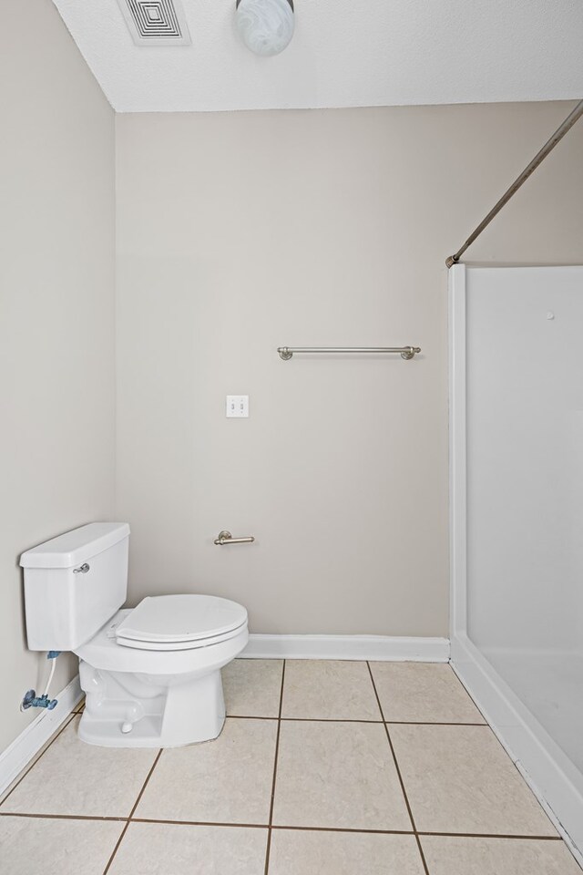4143 Whithorn Way, Valdosta, GA 31605 - bathroom with toilet, tile patterned flooring, a shower, and baseboards