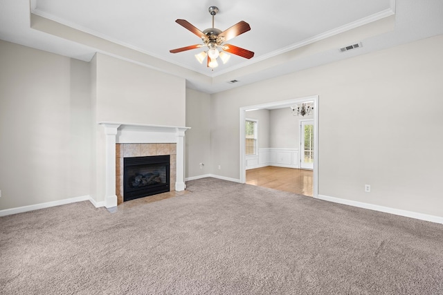 4143 Whithorn Way, Valdosta, GA 31605 - unfurnished living room featuring carpet, a raised ceiling, crown molding, a ceiling fan, and a tiled fireplace