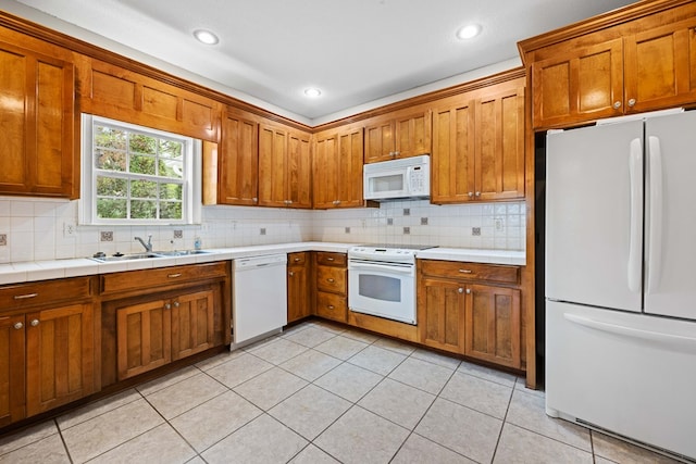 4143 Whithorn Way, Valdosta, GA 31605 - kitchen featuring white appliances, a sink, brown cabinetry, decorative backsplash, and light tile patterned flooring