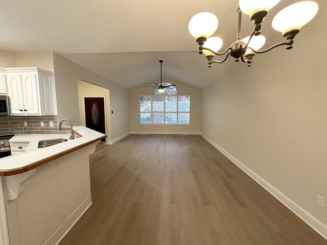 kitchen featuring white cabinetry, sink, backsplash, kitchen peninsula, and pendant lighting