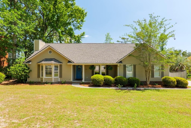 ranch-style home with a front lawn, a shingled roof, and a chimney
