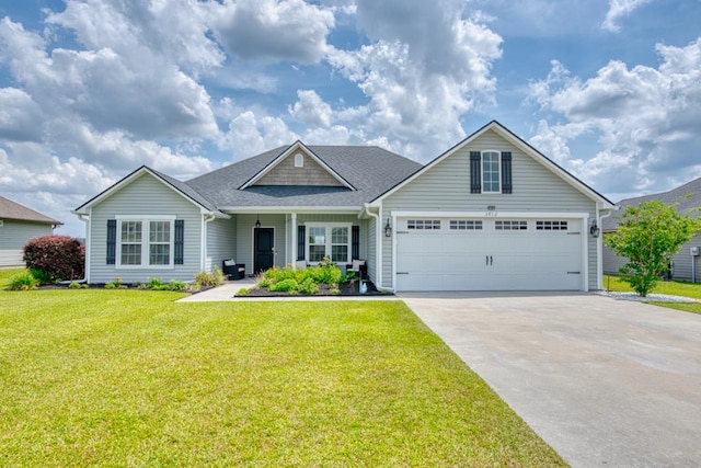 view of front of house with a shingled roof, driveway, a front yard, and a garage