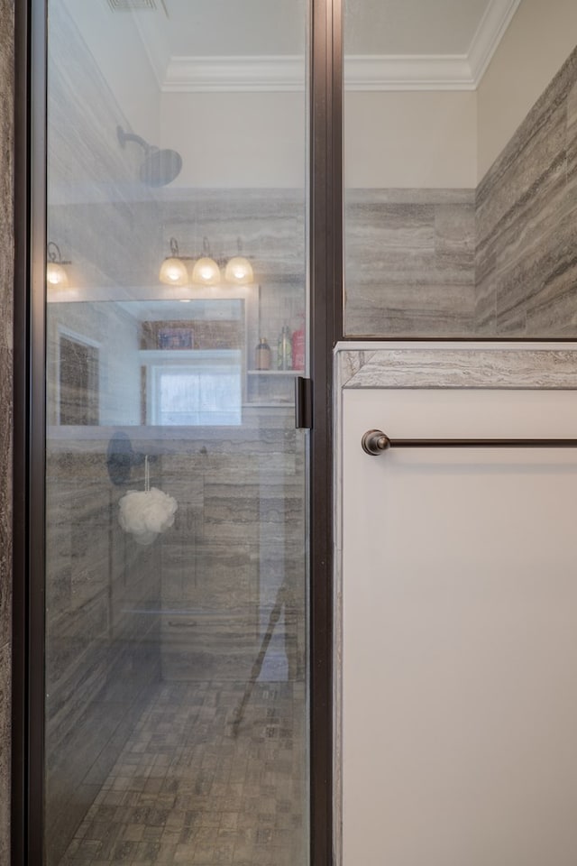 bathroom featuring a tile shower and ornamental molding