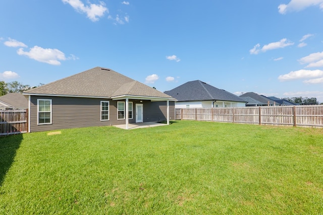 back of house featuring a lawn and a patio