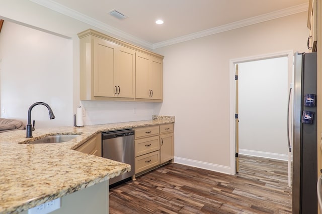 kitchen with light stone countertops, appliances with stainless steel finishes, sink, cream cabinets, and dark hardwood / wood-style floors