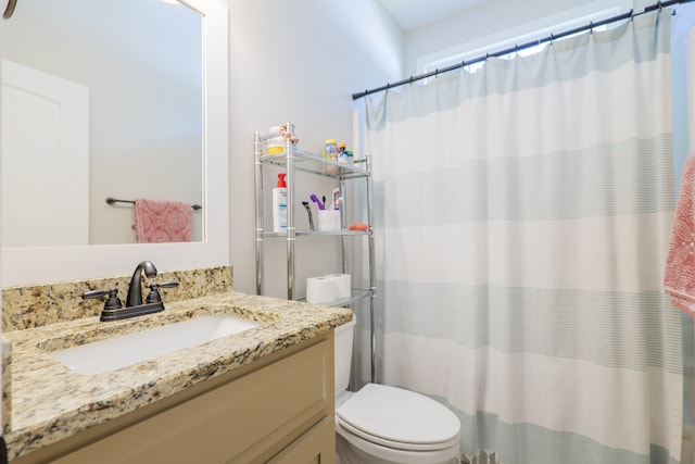 bathroom featuring walk in shower, vanity, and toilet