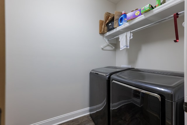 laundry room with independent washer and dryer and dark wood-type flooring