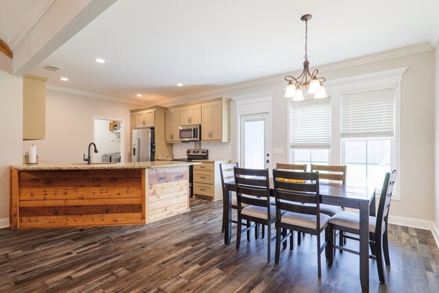 dining room featuring a notable chandelier, dark hardwood / wood-style floors, ornamental molding, and sink